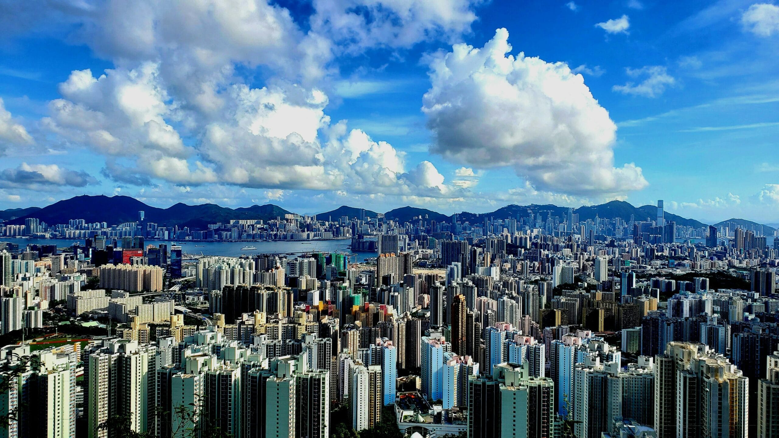A panoramic view of Hong Kong's skyline showcasing sleek, glass-clad skyscrapers and contemporary designs that embody urban elegance in a dynamic cityscape.