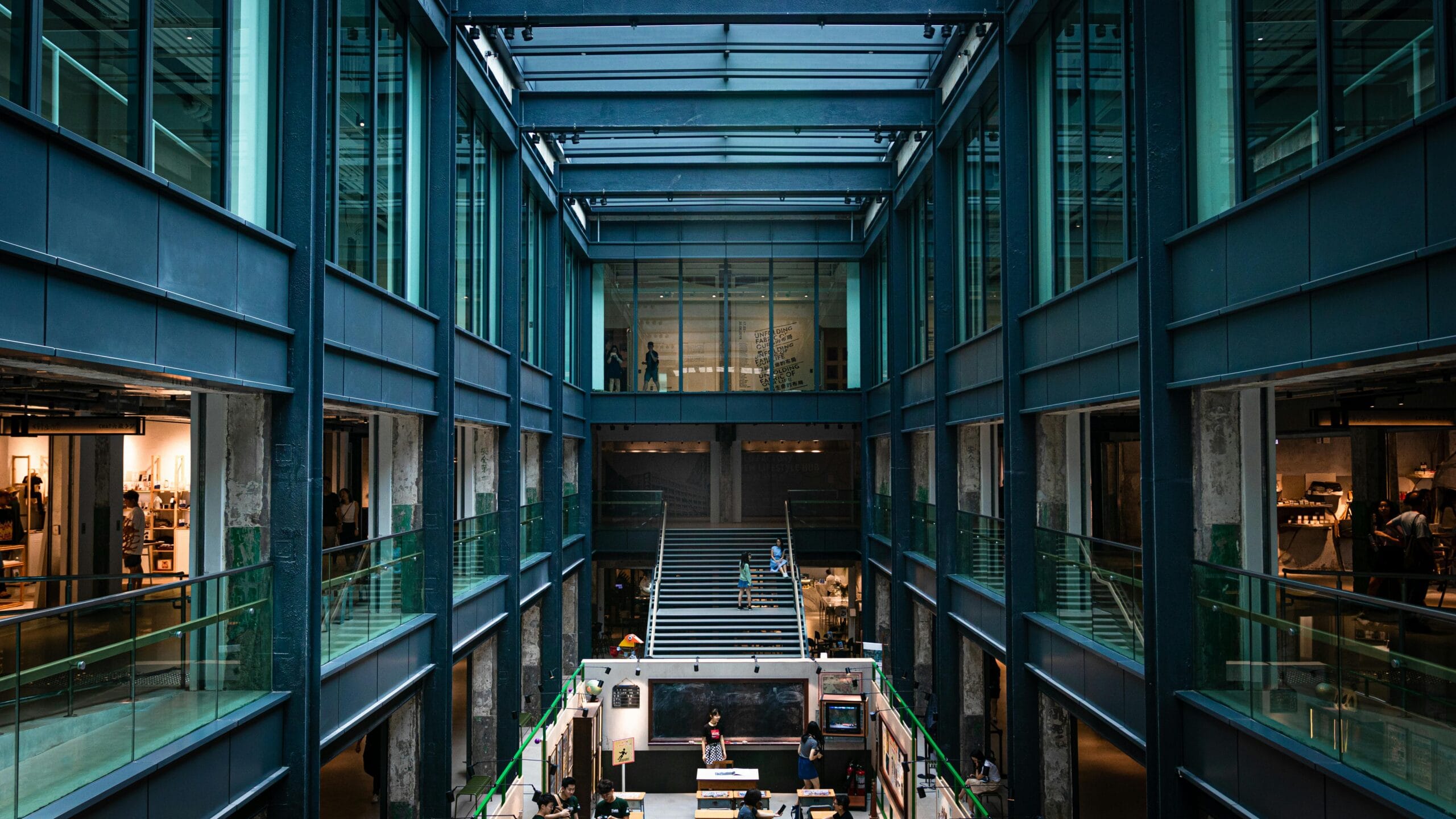 A renovated industrial building with glass walls, open walkways, and a modern workspace atmosphere