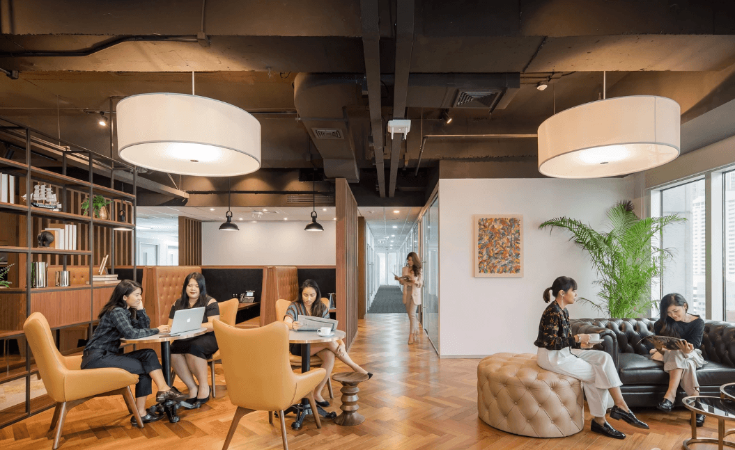 Modern coworking space with people working on laptops, relaxing, and enjoying a vibrant atmosphere.